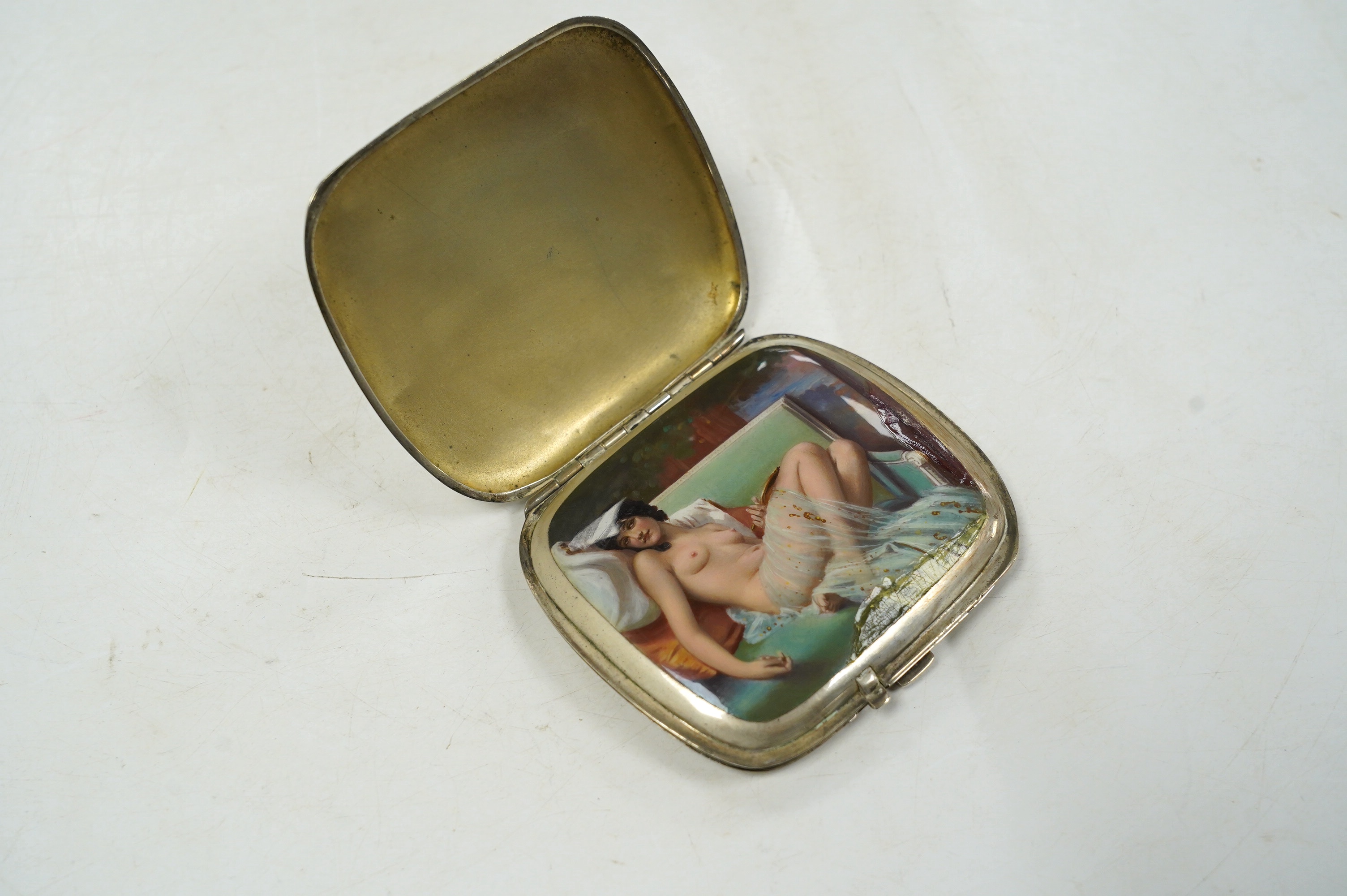 A 1920's/1930's German? 935 standard white metal cigarette case, with interior cover enamelled with a reclining nude (enamelled damaged and restored), 91mm, gross weight 6.1oz. Condition - poor